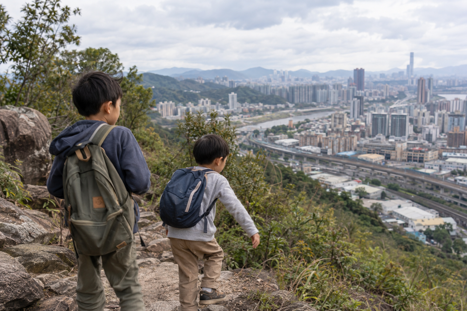 Two brothers exploring a city and railway from a mountain trail
